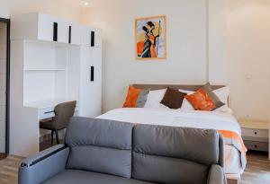 基加利Cozy Studio Retreat的一间卧室，配有一张床、一张沙发和一张书桌