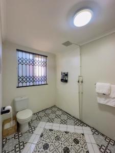 Un baño con inodoro y ventana. en Ladybird, en Durban