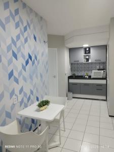 una cucina con un tavolo bianco e una parete con motivi blu di Flat Biarritz - Praia Litorânea a São Luís