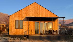 a large wooden house with a balcony and a table at Meronts in Yeghipatrush
