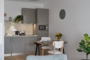 una cucina con tavolo e sedie in una cucina di DOMITYS - Galia a Brive-la-Gaillarde Altre 4 foto