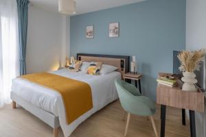 una camera da letto con un letto, una scrivania e una sedia di DOMITYS - Galia a Brive-la-Gaillarde