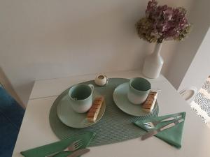a table with two coffee cups and cookies on it at Holiday House with scenic Apartment in Ptuj