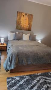 een slaapkamer met een groot bed met een schilderij aan de muur bij I Love Spa in Boedapest