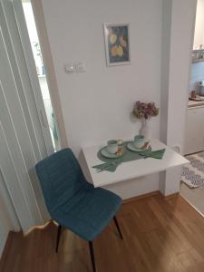 a white table and a blue chair in a room at Holiday House with scenic Apartment in Ptuj +13 photos