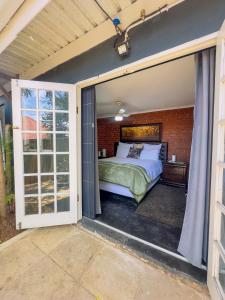 Un dormitorio con una cama en una habitación con ventana. en Ladybird, en Durban