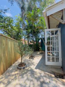 Un patio trasero con una puerta blanca y una cerca. en Ladybird, en Durban
