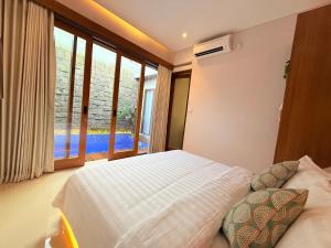 a bedroom with a bed and a large window at Genta Villa Bali in Sanur +23 photos