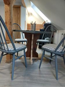 3 Stühle und ein Tisch in einem Zimmer in der Unterkunft Apartmány Arin in Jáchymov