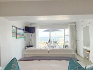 a bedroom with a bed and a view of the ocean at Harker Street Sea Facing Studio in Plettenberg Bay