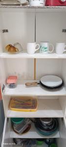 a white cabinet with cups and plates on it at Pousada Vôo Livre in Serra Talhada