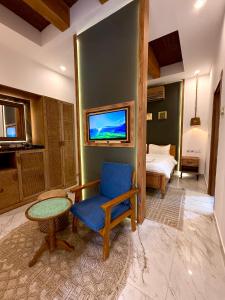 sala de estar con silla azul y TV en Nomad Inn Tiwi Albir, en Sur 2 fotos más