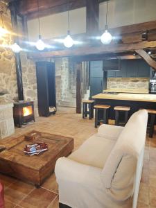 ein Wohnzimmer mit Couch und Kamin in der Unterkunft CASERIO RECTORAL DESTERIZ in Ourense