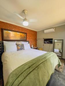 Un dormitorio con una cama grande y una pared de ladrillo. en Ladybird, en Durban