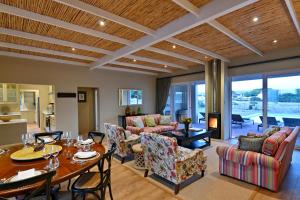 De Hoop Villa في De Hoop Nature Reserve: غرفة معيشة بها طاولة وكراسي