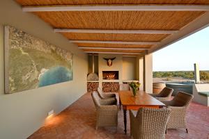 De Hoop Villa في De Hoop Nature Reserve: غرفة طعام مع طاولة وكراسي ومدفأة