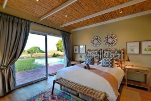 De Hoop Villa في De Hoop Nature Reserve: غرفة نوم بسرير كبير ونافذة كبيرة