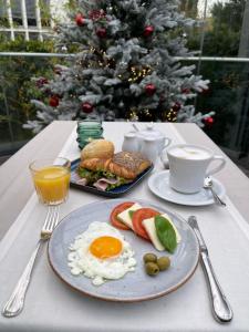 a table with a plate of breakfast food and a christmas tree at Villa Westend Hotel an der Messe in Frankfurt/Main