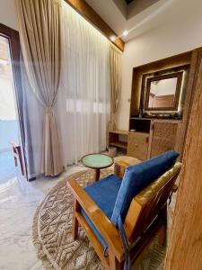 Una sala de estar con una silla y un espejo. en Nomad Inn Tiwi Albir, en Sur