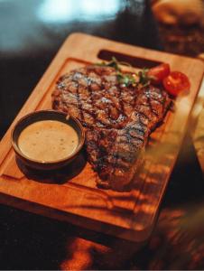 Ein Teller Steak mit Dip-Sauce auf einem Tisch in der Unterkunft Alliance palace Black Sea in Batumi