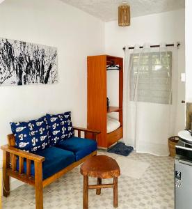 een woonkamer met een blauwe bank en een tafel bij Elala Studio Homes in Diani Beach +2 foto's