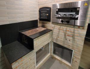 una cocina con estufa y microondas en SKYHOUSE BOUTIQUE - Loft & SPA - piscina aquecida e sauna privativa - Centro, Domingos Martins, en Domingos Martins 13 fotos más