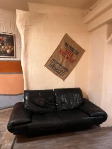 un divano in pelle nera in una stanza con parete di Vila Stern bei FFM Viel Platz und eigener Zugang a Nidderau