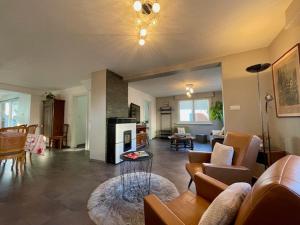 a living room with a couch and a fireplace at Chez L en Alsace - Maison avec jardin et piscine spa proche d'Obernai in Griesheim-près-Molsheim