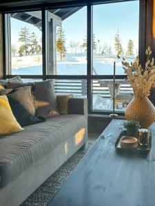 una sala de estar con un sofá y una mesa en Modern Cabin With Views Of Skeikampen, en Svingvoll 32 fotos más