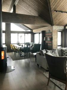 una sala de estar con un sofá, una mesa y sillas en Modern Cabin With Views Of Skeikampen, en Svingvoll