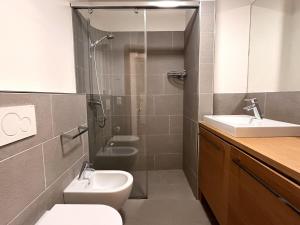 a bathroom with a shower and a toilet and a sink at Chesa Silvretta - Celerina in Celerina +25 photos