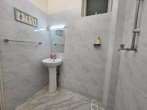 ein weißes Badezimmer mit Waschbecken und Dusche in der Unterkunft Charming cosy apartment in Mtwapa + 8 Fotos