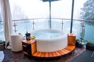 a large bath tub sitting in a room with a window at Hotel Tommy Wellness & Spa in Náchod +65 photos
