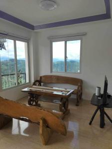 Habitación con cama, mesa y ventanas. en Minesview Transient Unit beside Minesview Park only, en Baguio