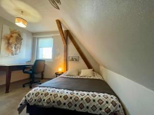 a bedroom with a bed and a desk in a room at Chez L en Alsace - Maison avec jardin et piscine spa proche d'Obernai in Griesheim-près-Molsheim
