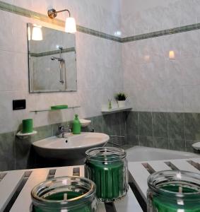 a bathroom with two green jars on a counter at Appartamento Albachiara in Revello +4 photos