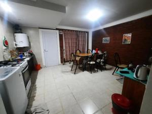 una cucina e una sala da pranzo con tavolo e sedie di Dina Huapi a Las Grutas
