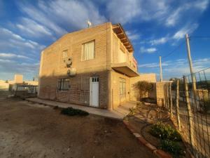 una casa di mattoni con una recinzione di fronte di Dina Huapi a Las Grutas