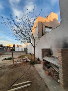 un albero di fronte a una casa con un edificio di Dina Huapi a Las Grutas Altre 8 foto