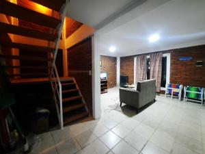 un soggiorno con scala e sedia di Dina Huapi a Las Grutas