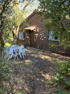 ein Tisch und Stühle vor einem Haus in der Unterkunft בקתת היערן- בטבע פראי למשפחות ולזוגות in Merom Golan