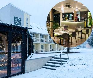 a reflection of a building with snow on the ground at Hét Vezér Apartmanhotel in Komárom