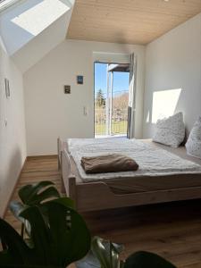 a bedroom with a bed and a large window at Ferien am Winkelhof in Deggenhausertal