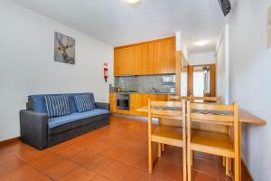 a kitchen and living room with a table and a couch at Gerês Cascatas Residence in Geres