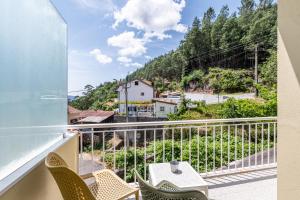 ジェレスにあるGerês Cascatas Residenceの椅子と山の景色が見えるバルコニー