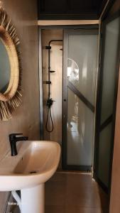 a bathroom with a sink and a glass shower at Rock Surf Hostel Taghazout in Taghazout +54 photos