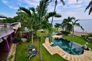 uma vista aérea de um quintal com uma piscina e o oceano em Dolphin Beach Bali em Lovina