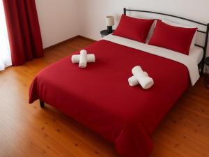 a bedroom with a red bed with two pillows at 3 Mountains Luxury House in Aridaia