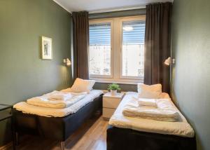 two beds in a room with a window at Göteborg Hostel in Gothenburg +55 photos