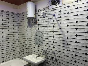 baño con paredes en blanco y negro y lavabo en mshotel Loharu, en Lohāru 10 fotos más